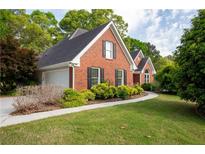 Charming brick home with black shutters and lush landscaping on a well-manicured lawn at 1270 Tribble Walk Ct, Lawrenceville, GA 30045