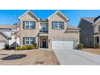 Charming two-story home boasts a two-car garage, manicured lawn, and classic architectural details at 1452 Weatherbrook Cir, Lawrenceville, GA 30043