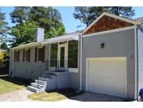 Charming brick home with a white garage door, screened porch, and mature landscaping at 2381 Eastway Rd, Decatur, GA 30033
