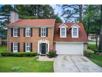 Charming brick home featuring black shutters, dormer windows, and a well-manicured lawn at 3099 Regency Park Dr, Lithonia, GA 30038