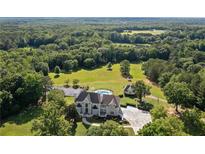 Expansive estate featuring a stately home, in-ground pool, lush landscaping, and sprawling acreage surrounded by mature trees at 1481 Highway 85 Connector, Brooks, GA 30205