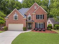 Charming two-story brick home with a well-manicured lawn and attached two-car garage at 350 Medridge Dr, Johns Creek, GA 30022