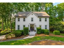 Charming two-story home with a landscaped front yard and classic white brick facade at 1590 Greyson Rdg, Marietta, GA 30062