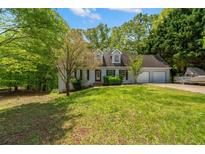 Charming single-Gathering home featuring dormer windows, a well-manicured lawn, and an attached two-car garage at 165 Colony Cir, Canton, GA 30114