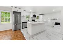 Bright kitchen with stainless steel appliances, white cabinetry, and island with countertop at 2702 Galaxy Ct, Decatur, GA 30034