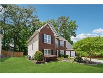 Charming two-story brick home with a well-manicured lawn, and mature trees enhancing its curb appeal at 6034 Farmwood Se Way, Mableton, GA 30126