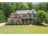 Charming two-story brick home featuring a well-manicured lawn and professional landscaping at 3230 Sundew Nw Dr, Acworth, GA 30101