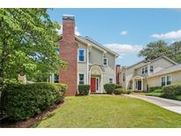 Charming townhome featuring a red front door, brick chimney, and well-manicured lawn at 267 Somerlane Pl, Avondale Estates, GA 30002
