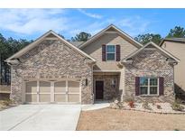 Charming brick home with a two-car garage, landscaped front yard, and inviting front entrance at 3415 Linstead Ct, Loganville, GA 30052