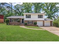 Charming two-story home with a brick and siding exterior, large front lawn, and two car garage at 6997 Vesta Brook Dr, Morrow, GA 30260