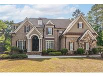Charming two-story brick home featuring manicured lawn and mature trees at 1584 Water Springs Way, Dacula, GA 30019