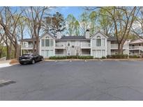 Condominium exterior with gray siding, a black roof, balconies, and ample parking at 204 Countryside Se Pl # 204, Smyrna, GA 30080