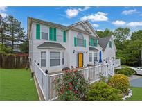 Charming two-story home featuring a bright yellow front door, green shutters, and a well-manicured front yard at 6031 Hitt Lake Ct, Stone Mountain, GA 30087