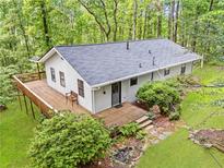 View of home with a new roof, expansive deck, surrounded by lush forest at 6650 Bobby John Rd, Atlanta, GA 30349