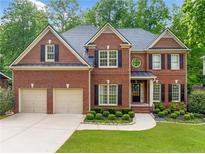 Traditional brick home featuring an attached two-car garage and manicured lawn at 790 Sienna Dr, Cumming, GA 30040