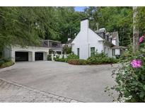 Elegant white brick home with a spacious driveway and a detached two-car garage at 1 Habersham Nw Way, Atlanta, GA 30305