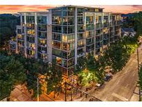 Beautiful mid-rise apartment building with glass windows and balconies, surrounded by mature trees at sunset at 905 Juniper Ne St # 808, Atlanta, GA 30309