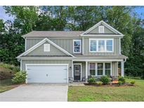 Charming two-story home featuring a two-car garage and a welcoming front porch in a well-manicured yard at 741 Jackson Ct, Social Circle, GA 30025
