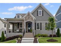 Charming home featuring brick and stone accents, a cozy front porch, and a well-manicured lawn at 2003 Haley Walk, Woodstock, GA 30188