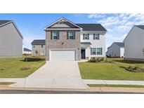 Charming two-story home with a brick and siding exterior, attached garage, and well-manicured lawn at 45 Vermillion Trl, Covington, GA 30016