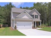 Charming two-story home featuring a two-car garage and well-manicured lawn, surrounded by lush trees and landscaping at 48 Beaver Pt, Villa Rica, GA 30180