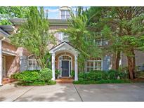 Elegant brick home featuring a welcoming front entrance with a covered porch and lush landscaping at 4470 Crestwicke Pointe, Atlanta, GA 30319