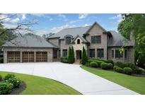 Charming two-story brick home with three-car garage, manicured lawn and a stone archway entrance at 22 Mount Paran Rd, Atlanta, GA 30327