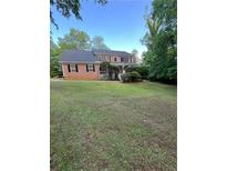 Traditional two-story home featuring a well-manicured front yard and mature trees at 5142 Fawn Sw Ln, Conyers, GA 30094