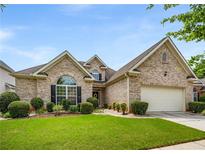 Charming brick home with manicured lawn, complemented by mature shrubs and an attached two-car garage at 7994 Larksview Dr, Fairburn, GA 30213