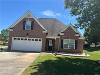 Charming brick home with attached garage and well-maintained lawn on a sunny day at 1266 Laurelwood Ct, Lawrenceville, GA 30045