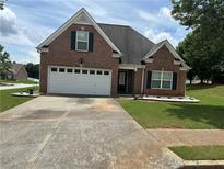 Charming, one-story brick home featuring a two-car garage and well-maintained landscaping at 1266 Laurelwood Ct, Lawrenceville, GA 30045