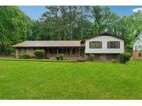 Charming single-Gathering home featuring brick accents, a covered porch, and a lush green lawn at 2255 Chippewa Dr, Riverdale, GA 30296