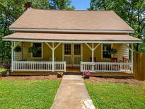 Charming home featuring a cozy front porch with classic railings and a well-maintained lawn at 500 Nolan Rd, Carrollton, GA 30116
