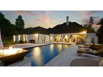 Inviting backyard featuring a luxurious pool, fire pit, lounge chairs, and covered outdoor seating area at , Buford, GA 30518