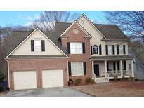 Charming two-story brick and beige home with a two-car garage and covered front porch at 138 Knightwood Pt, Acworth, GA 30101