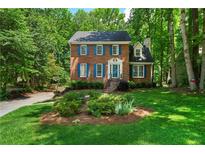 Charming two-story brick home with blue shutters and a well-manicured lawn and lush green trees at 1769 Milford Creek Sw Cts, Marietta, GA 30008