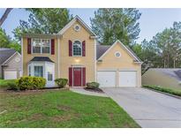 Charming two-story home with a well-manicured lawn, two-car garage, and inviting red front door at 7113 Ambercrest Ct, Austell, GA 30168