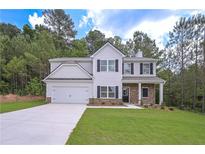 Charming two-story home with a manicured lawn, stone accents, and an attached two-car garage at 16 Deer Place, Villa Rica, GA 30180