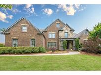 Beautiful brick and stone home featuring manicured lawn, professional landscaping and inviting front entrance at 6345 Sterling Shores Dr, Cumming, GA 30041
