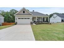 Charming single-Gathering home with a manicured lawn, attached garage, and inviting covered porch at 6830 Heard Ln, Cumming, GA 30041