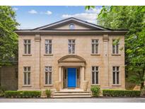 Elegant stone home featuring a striking blue front door, symmetrically designed windows, and manicured landscaping at 973 Peachtree Battle Ave, Atlanta, GA 30327