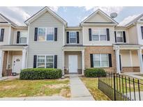Charming townhouse featuring a well-manicured lawn and classic architectural details at 2255 Bigwood Trl, Atlanta, GA 30349