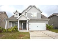 Charming two-story home with gray siding, a covered porch, and a two-car garage at 2522 Bear Mountain St, Lithonia, GA 30058