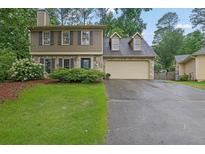 Charming two-story home featuring stone accents, a two-car garage, and a well-manicured front lawn at 3470 Whisperwood Nw Ct, Marietta, GA 30064