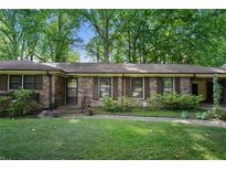 Charming brick home featuring wood shutters, a well-maintained lawn, and mature trees for shade and curb appeal at 2175 Fisher Ne Trl, Atlanta, GA 30345