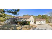 Charming home featuring a large driveway leading to both attached and detached two-car garages at 140 Moseley Dr, Stockbridge, GA 30281