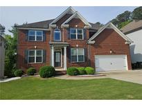 Charming two-story brick home with a well-manicured lawn and a two-car garage at 232 Clubhouse Xing, Acworth, GA 30101