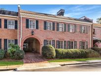 Charming two-story brick townhome featuring a covered entrance, symmetrical windows, and well-maintained landscaping at 3456 Paces Nw Pl, Atlanta, GA 30327