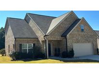 Charming single-Gathering home with a brick facade, manicured lawn, and a two-car attached garage at 457 Panhandle Pl, Hampton, GA 30228