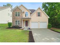 Charming two-story home featuring a stone facade, two-car garage, and well-manicured lawn at 237 River Pass Ct, Dacula, GA 30019